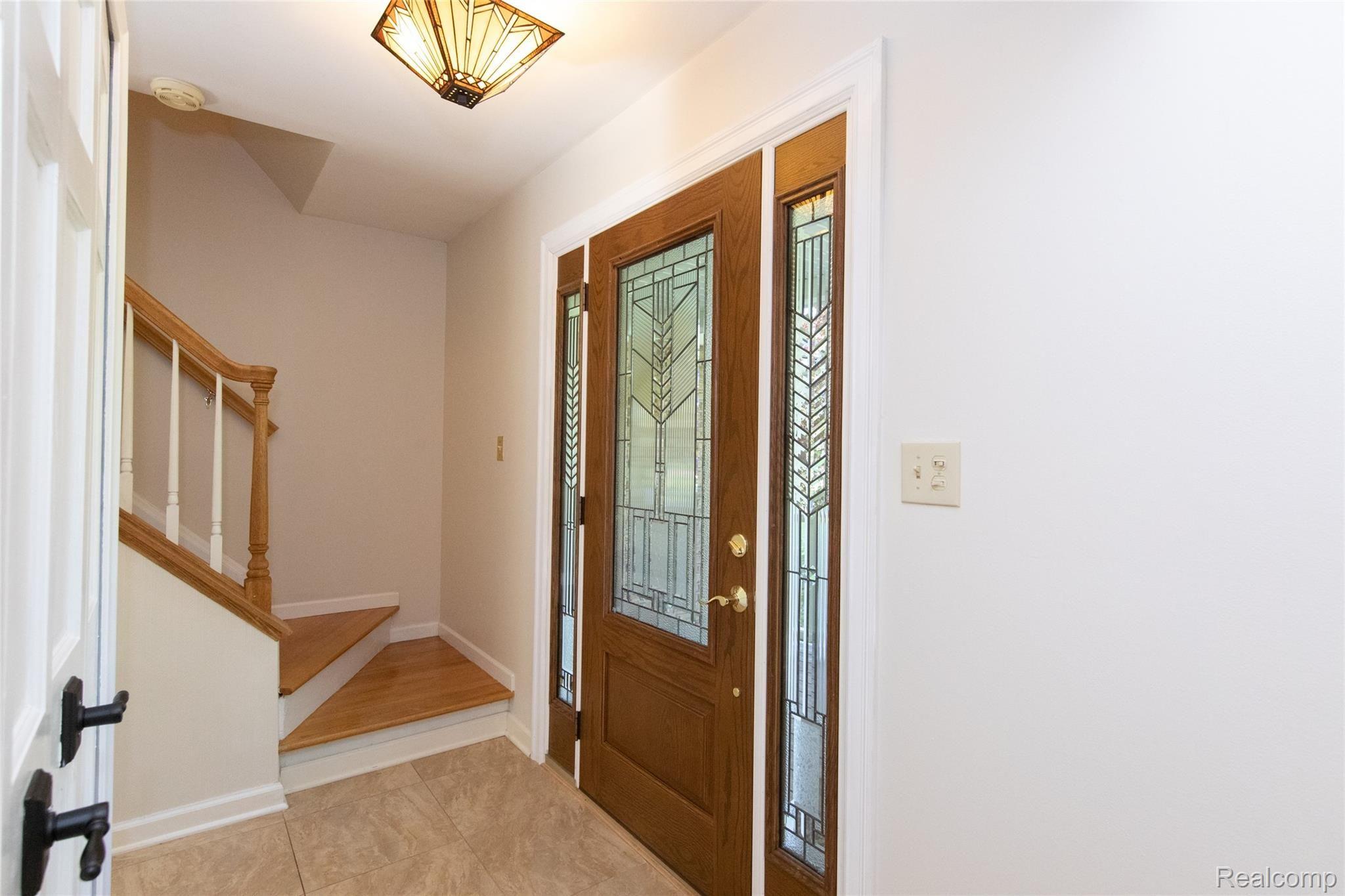 8117 Reese Road Clarkston, MI 48348 - Photo 11 of 41 Beautiful leaded glass entry way into the home with porcelain tile flooring.