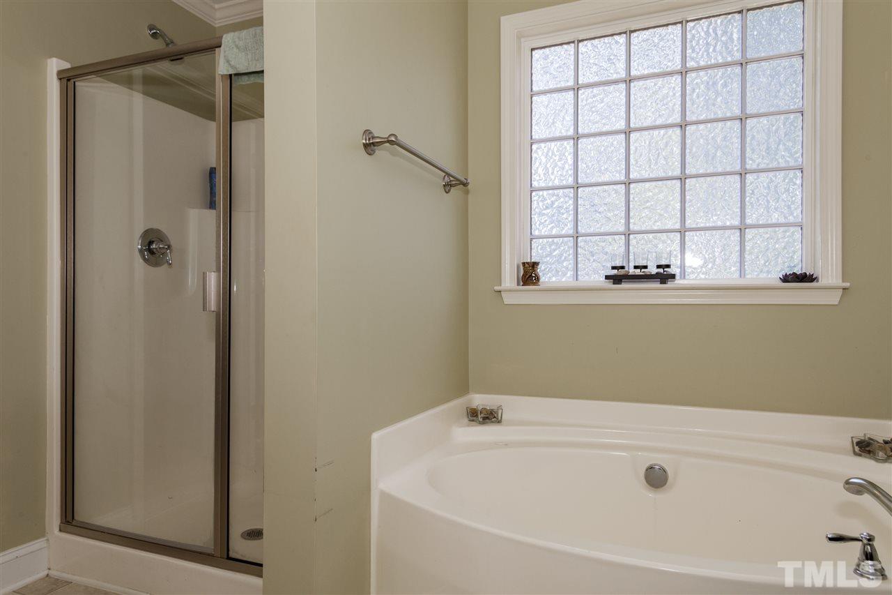 5607 Spring Glen Lane Raleigh, NC 27616 - Photo 11 of 21 a bathroom with a bathtub and window
