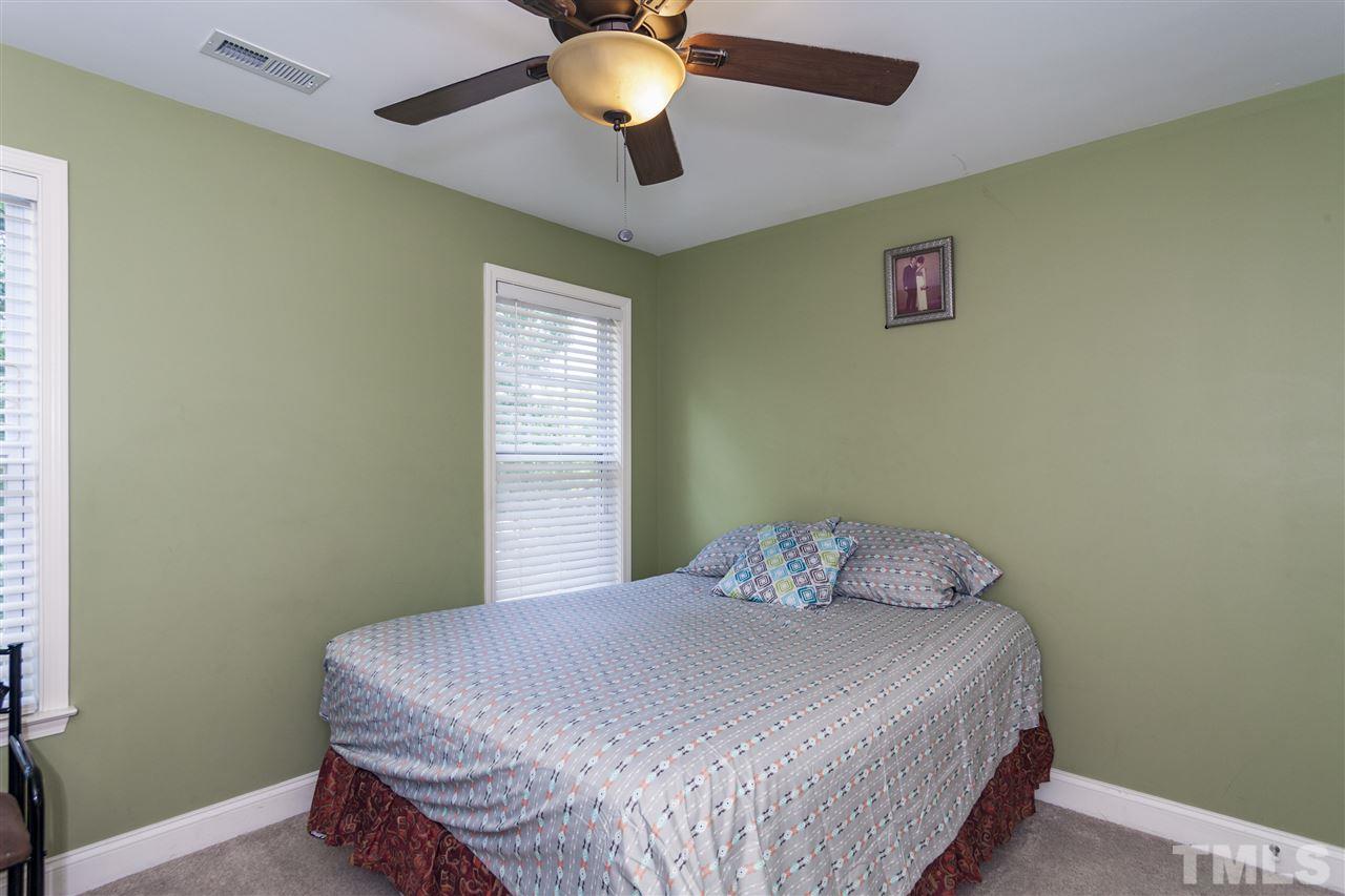 5607 Spring Glen Lane Raleigh, NC 27616 - Photo 12 of 21 a bedroom with a bed and a chandelier