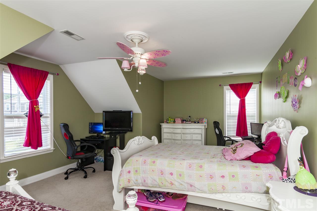 5607 Spring Glen Lane Raleigh, NC 27616 - Photo 16 of 21 a bedroom with a bed and a chandelier