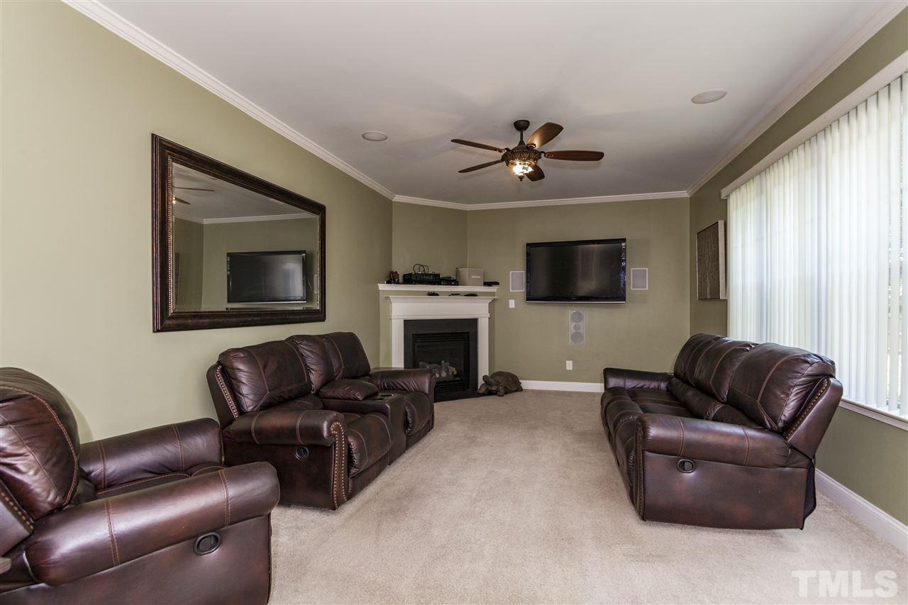 5607 Spring Glen Lane Raleigh, NC 27616 - Photo 7 of 21 a living room with furniture a flat screen tv and a fireplace