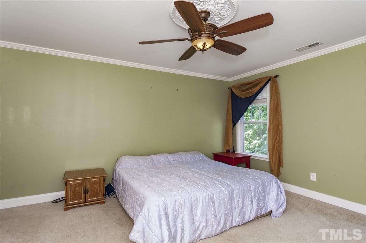 5607 Spring Glen Lane Raleigh, NC 27616 - Photo 8 of 21 a bedroom with a bed and a ceiling fan
