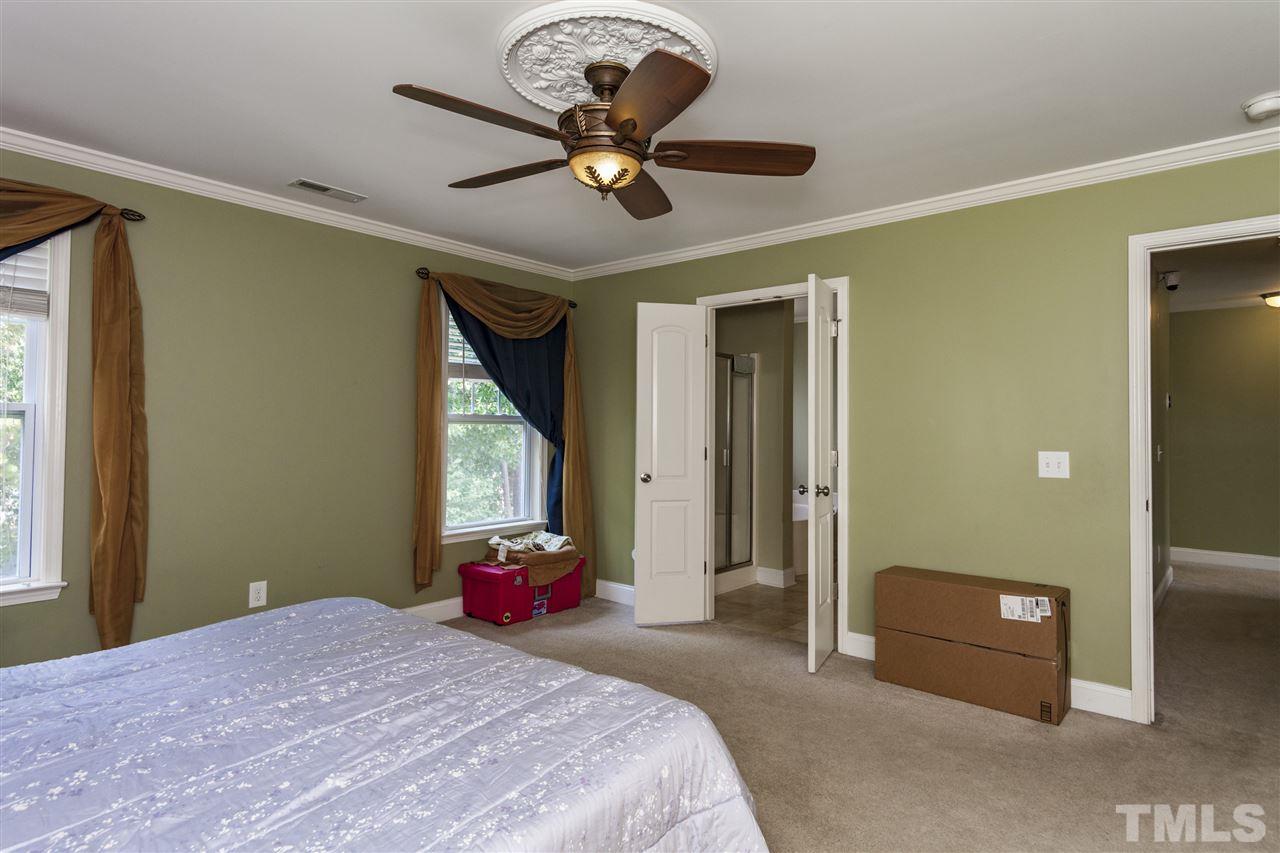 5607 Spring Glen Lane Raleigh, NC 27616 - Photo 9 of 21 a bedroom with a bed and a chandelier
