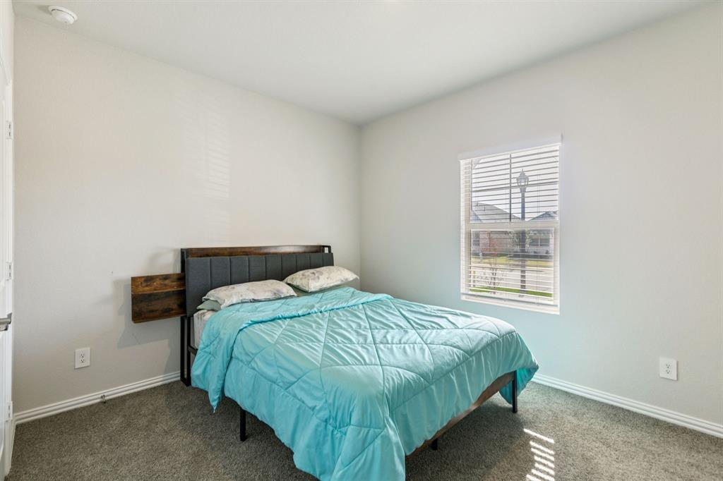 1008 Edgehurst Drive McKinney, TX 75071 - Photo 10 of 17 a bed sitting in a bedroom next to a window