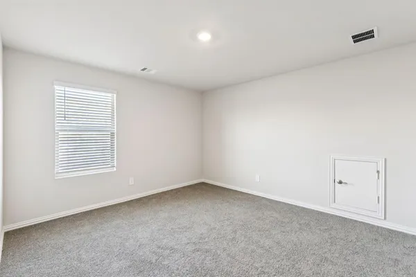 an empty room with window and ceiling fan