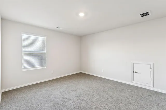 an empty room with window and ceiling fan