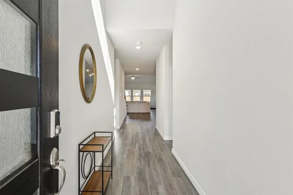 a view of a hallway with wooden floor and glass door
