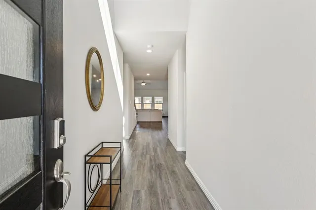 a view of a hallway with wooden floor and glass door