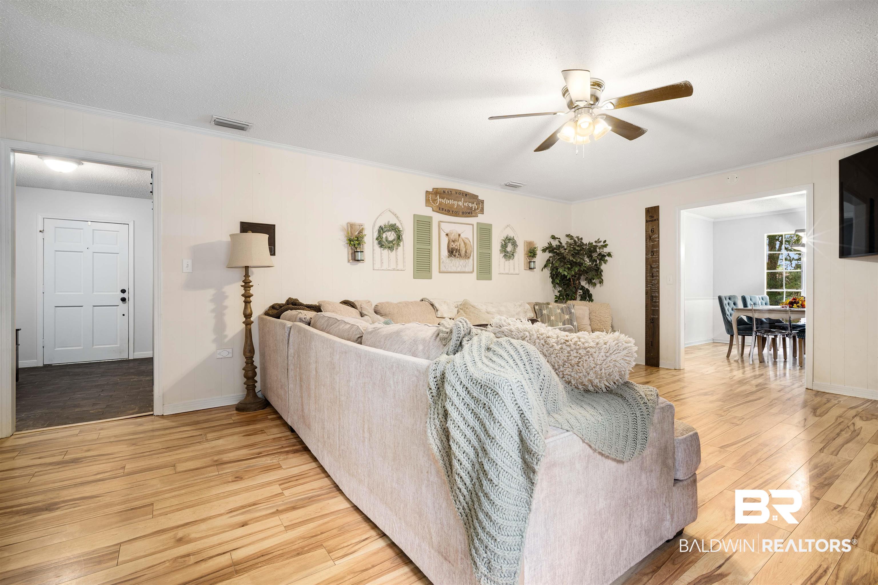 7807 Yorkhaven Road Mobile, AL 36695 - Photo 6 of 34 Living room featuring ornamental molding, light wood-type flooring, a ceiling fan, and a textured ceiling