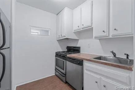 a kitchen with granite countertop white cabinets and a sink