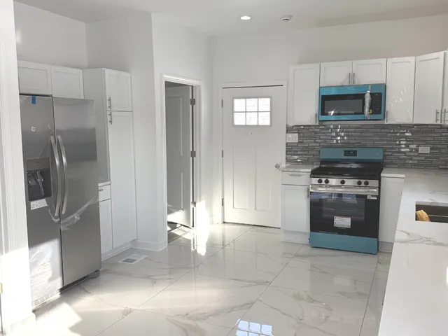 a kitchen with stainless steel appliances granite countertop a refrigerator and a stove top oven