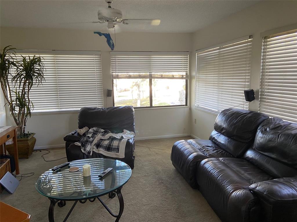 11450 Harbor Way, Unit 5002 Largo, FL 33774 - Photo 8 of 25 a living room with furniture a table and a window