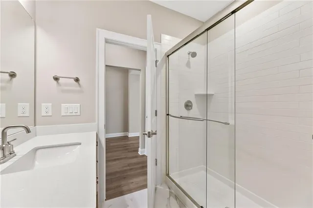 a view of an empty room with wooden floor fireplace and a window
