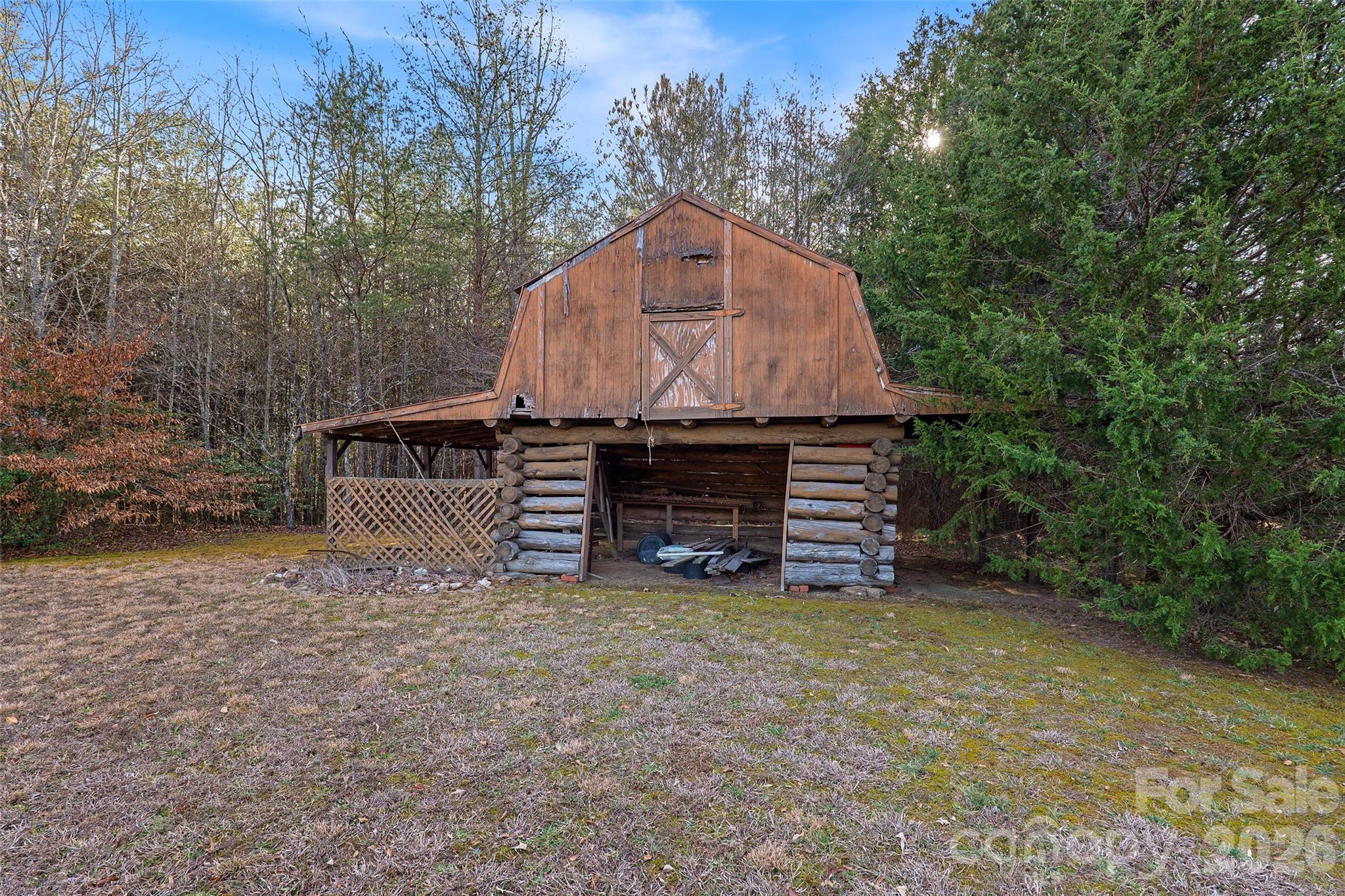 591 Landrum Road Tryon, NC 28782 - Photo 5 of 48 a view of a wooden house with a small yard and large trees