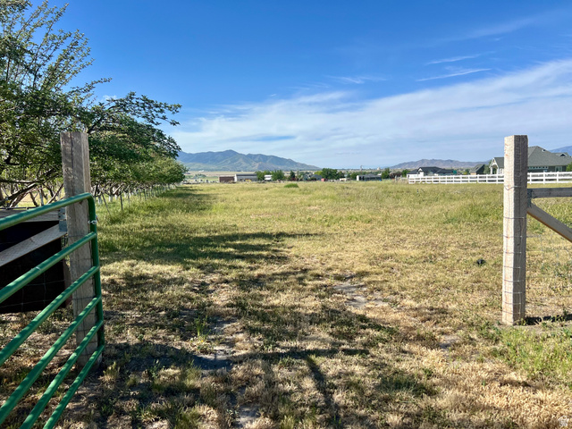 812 East Bates Cyn Road Tooele, UT 84074 - Photo 112 of 144 Expansive open land with a green metal gate and sturdy wooden posts