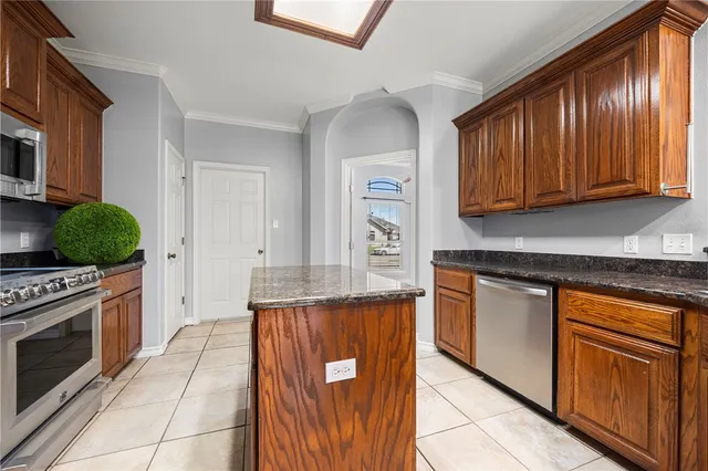 a kitchen with stainless steel appliances granite countertop a stove a sink and a refrigerator