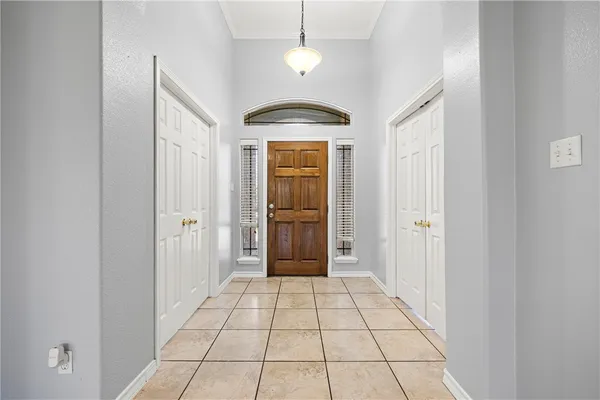a view of a hallway with a chandelier fan and windows