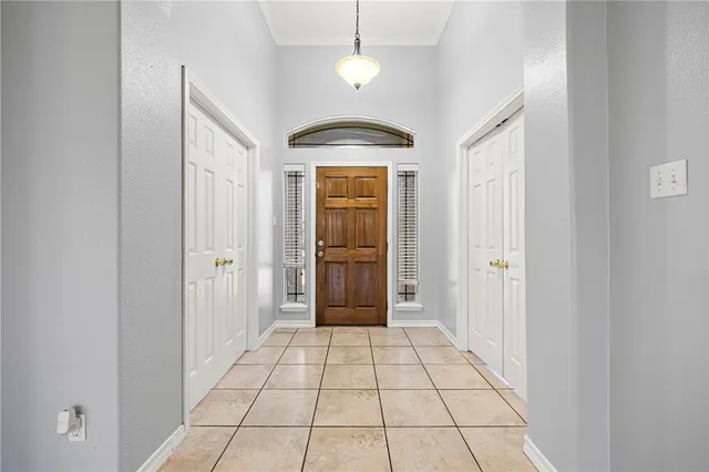 a view of a hallway with a chandelier fan and windows