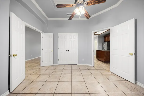 a view of an empty room and chandelier fan