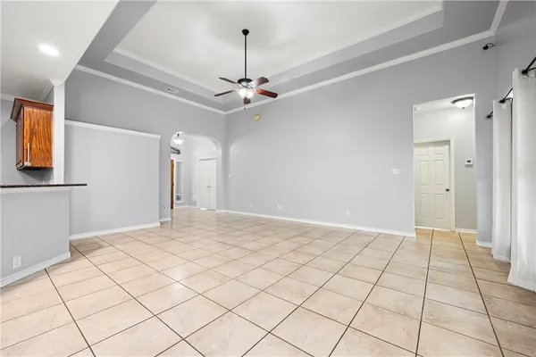 a view of an empty room and chandelier fan