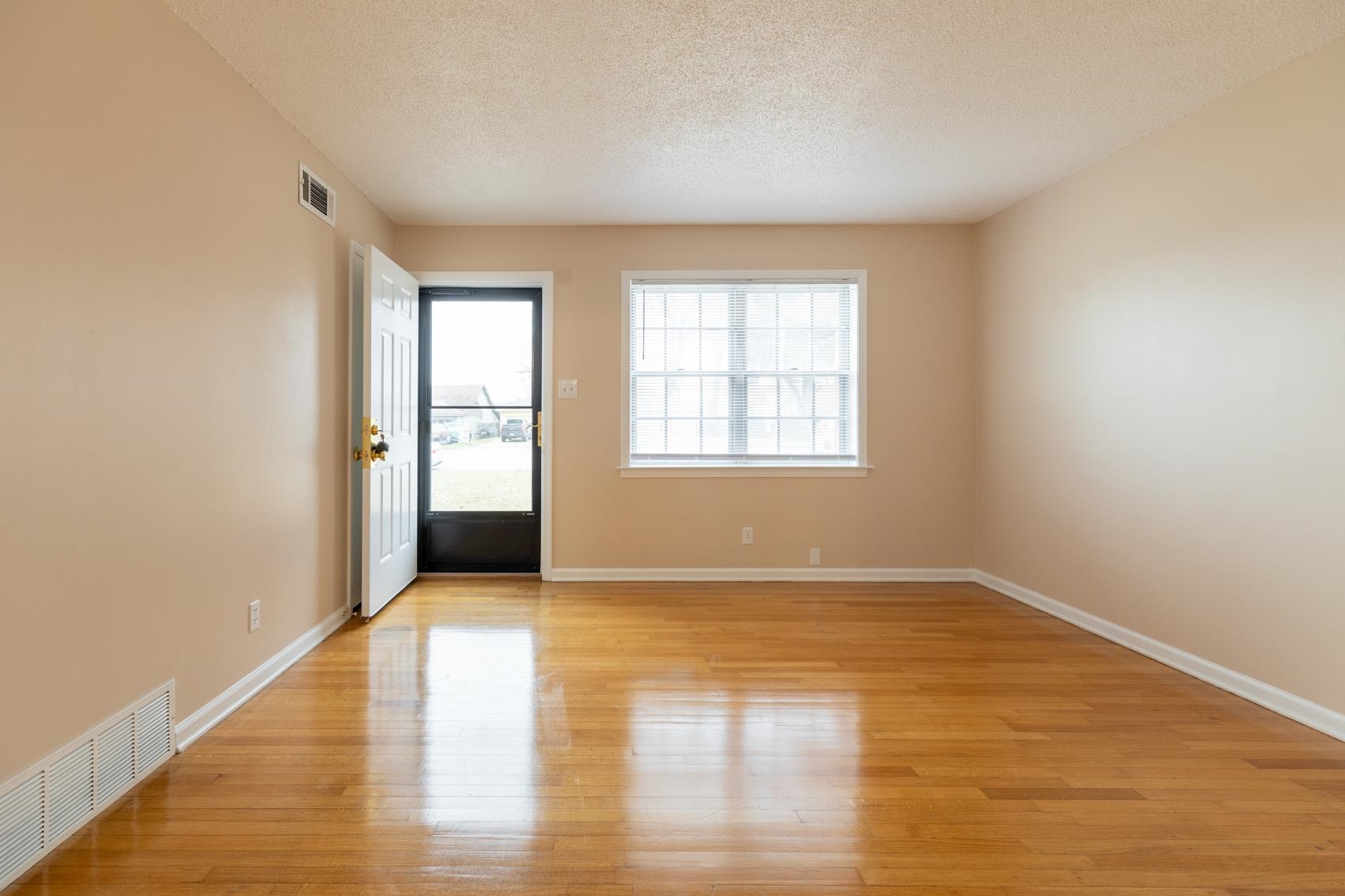 1820 West Holmes Road Memphis, TN 38109 - Photo 2 of 25 an empty room with wooden floor and windows