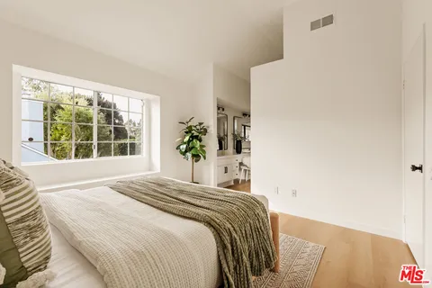 a bedroom with a bed and a large window