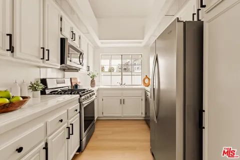 a kitchen with stainless steel appliances granite countertop a refrigerator and a stove