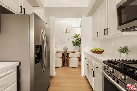 a kitchen with stainless steel appliances a stove a refrigerator and cabinets