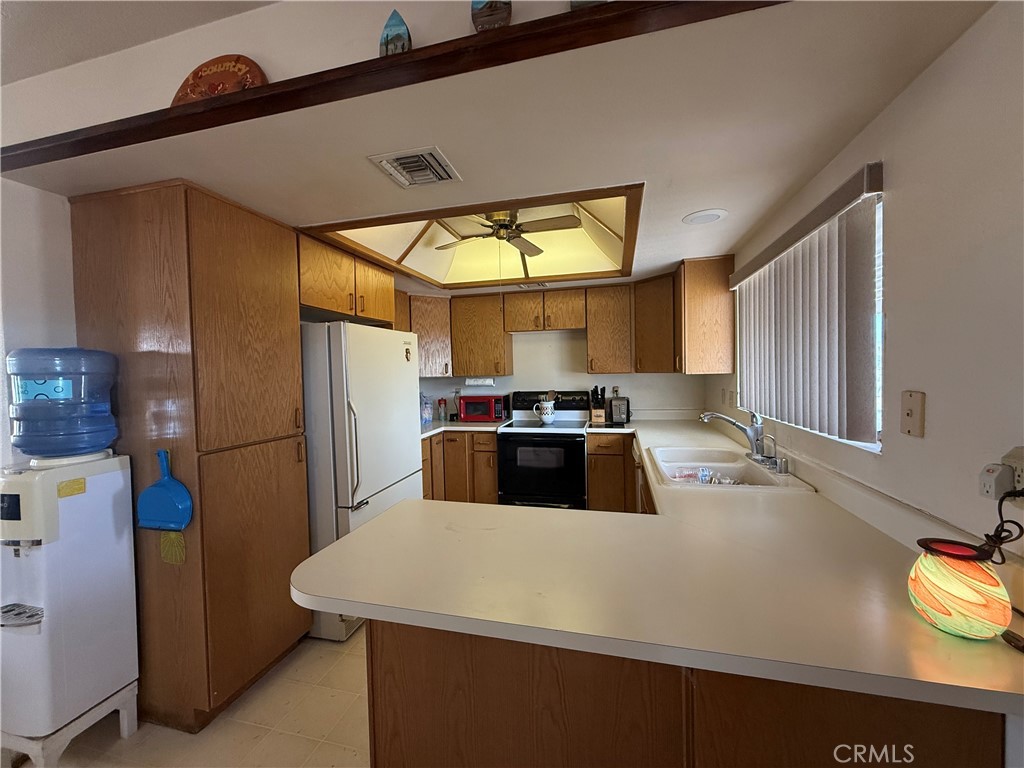 151080 Deerpath Road Big River, CA 92242 - Photo 6 of 24 a kitchen with a refrigerator a stove a sink and a window