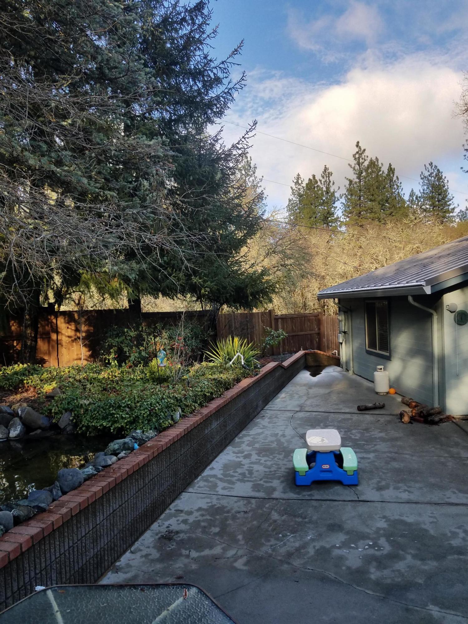 7837 Colonial Way Central Point, OR 97502 - Photo 17 of 25 a view of a patio with table and chairs with wooden fence