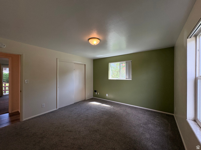 595 Meadowlark Road Orem, UT 84097 - Photo 43 of 87 Carpeted room featuring a single window with blinds, a contrasting accent wall, a flush-mount ceiling light fixture, and a closet with sliding doors