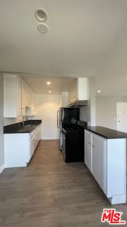 a large kitchen with a large counter top stainless steel appliances and cabinets