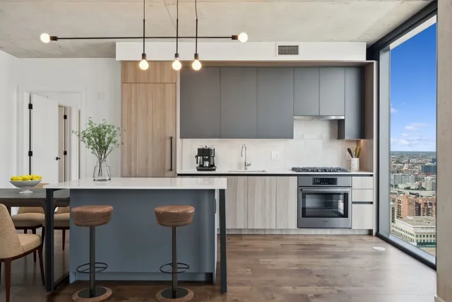 a kitchen with granite countertop a table chairs stove and cabinets
