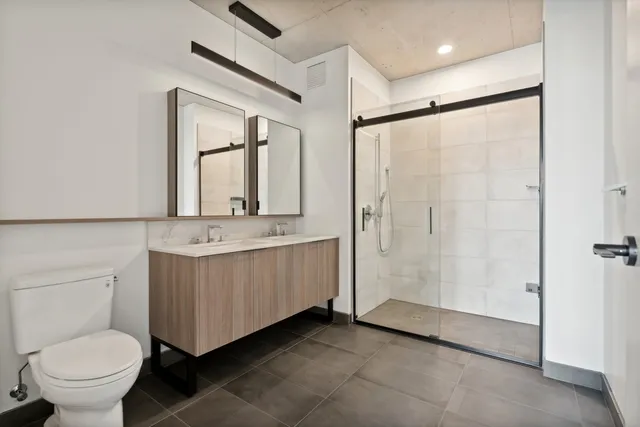 a bathroom with a double vanity sink toilet and a mirror