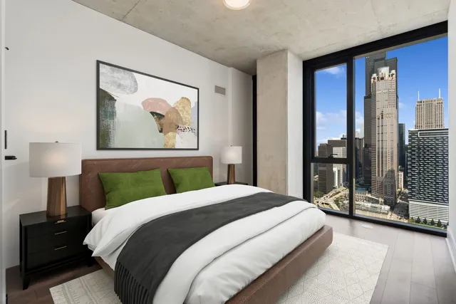 a bedroom with a large bed and a painting on the wall