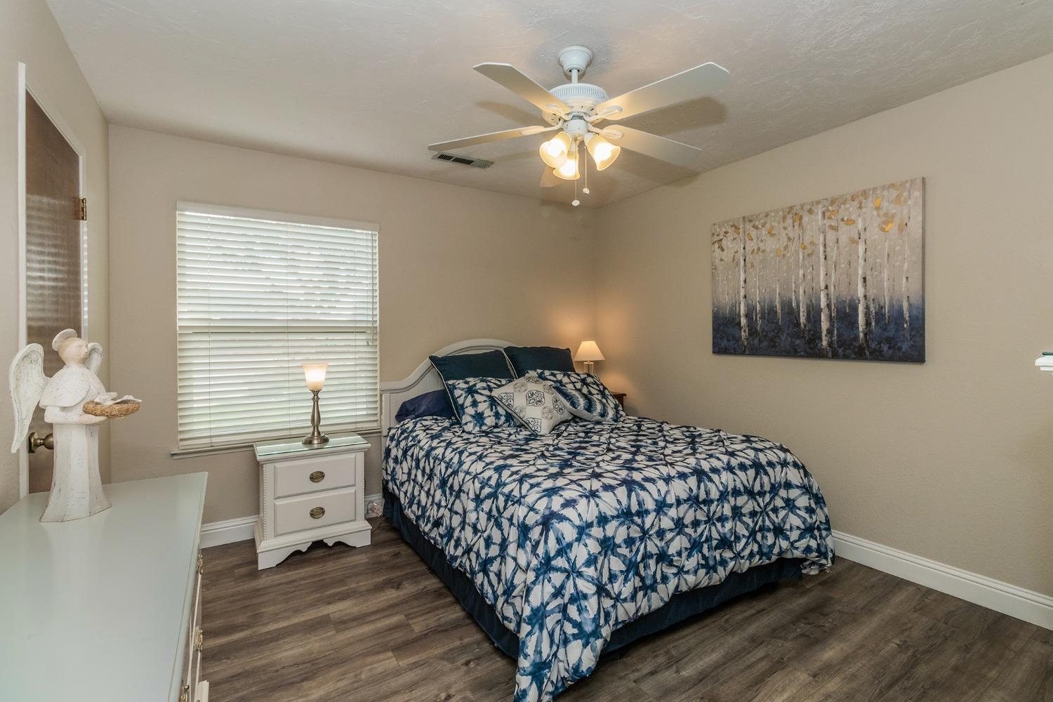6233 South Armstrong Avenue Fowler, CA 93625 - Photo 17 of 30 a bedroom with a large bed and a chandelier