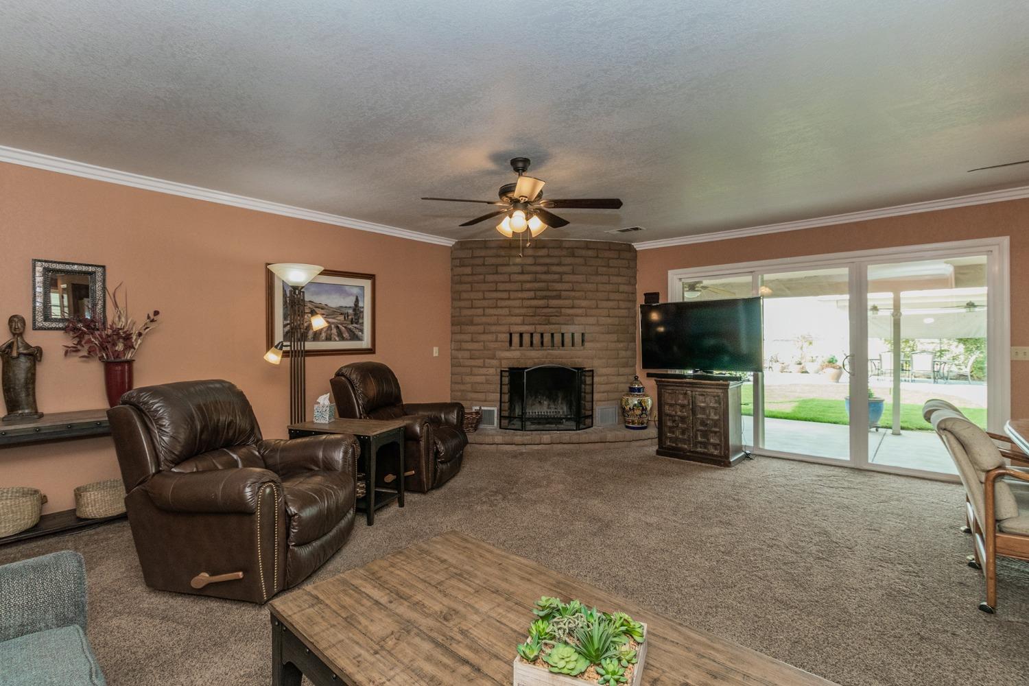 6233 South Armstrong Avenue Fowler, CA 93625 - Photo 8 of 30 a living room with furniture a fireplace a flat screen tv and a fireplace