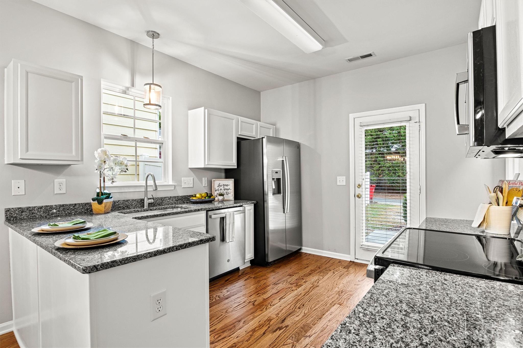 241 Faust Road Davidson, NC 28036 - Photo 11 of 29 a kitchen with a refrigerator a stove a sink a window and wooden floor