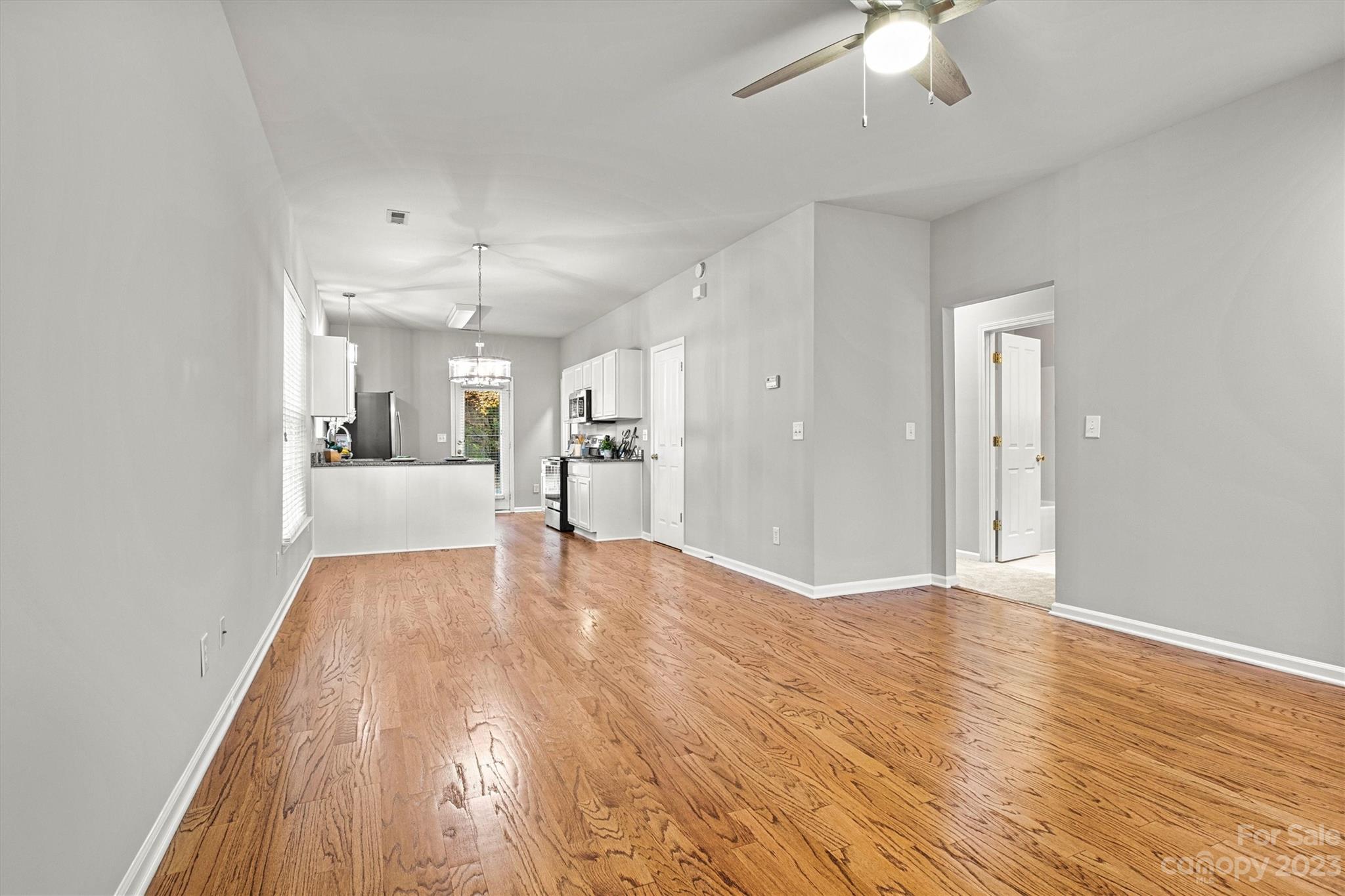 241 Faust Road Davidson, NC 28036 - Photo 5 of 29 a view of a livingroom with a furniture wooden floor and a ceiling fan