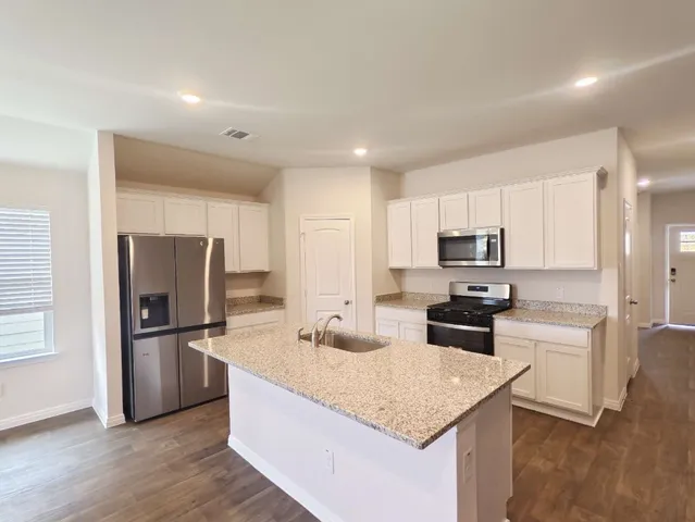 a kitchen with stainless steel appliances granite countertop a refrigerator stove microwave and sink