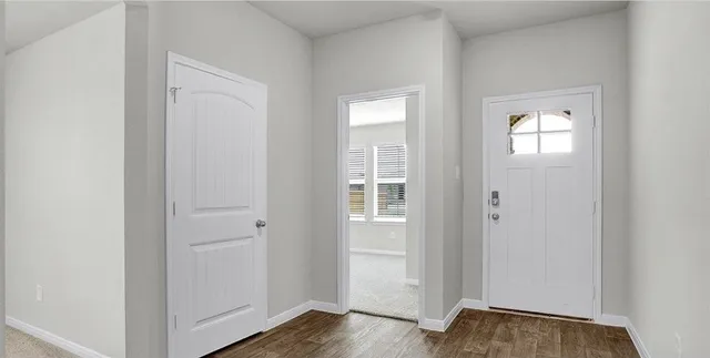a view of a room with wooden floor closet and windows