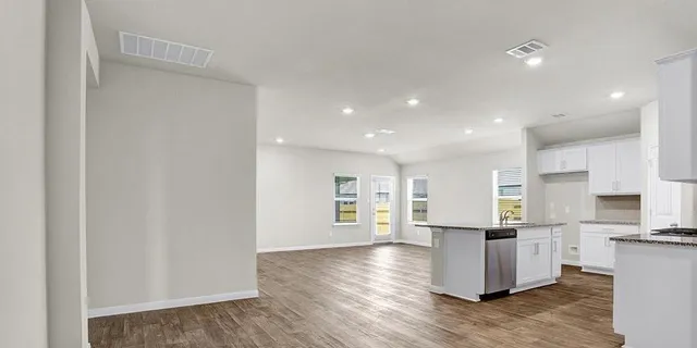 a kitchen with stainless steel appliances granite countertop a refrigerator and a stove top oven