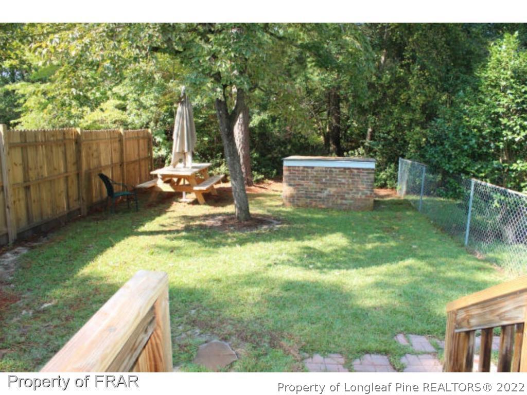 148 Ashemont Road Aberdeen, NC 28315 - Photo 12 of 18 a view of a backyard with table and chairs and wooden fence