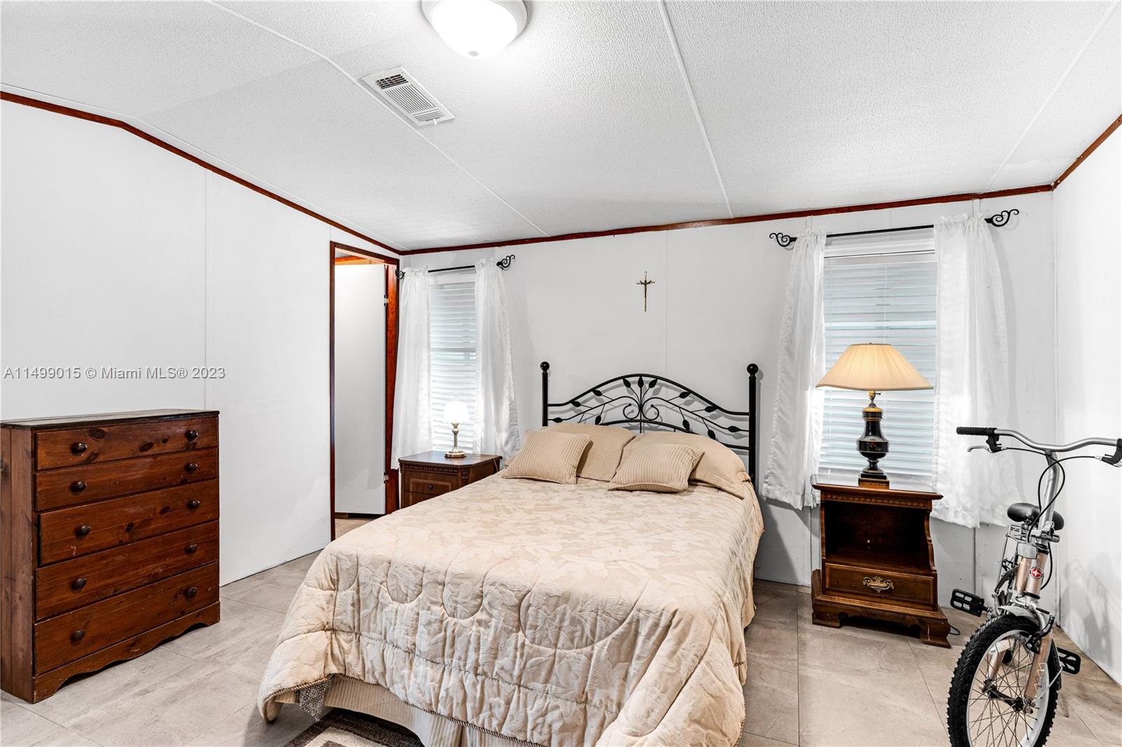 35250 Southwest 177th Court, Unit 77 Homestead, FL 33034 - Photo 17 of 30 a bedroom with a bed and a dresser with the mirror