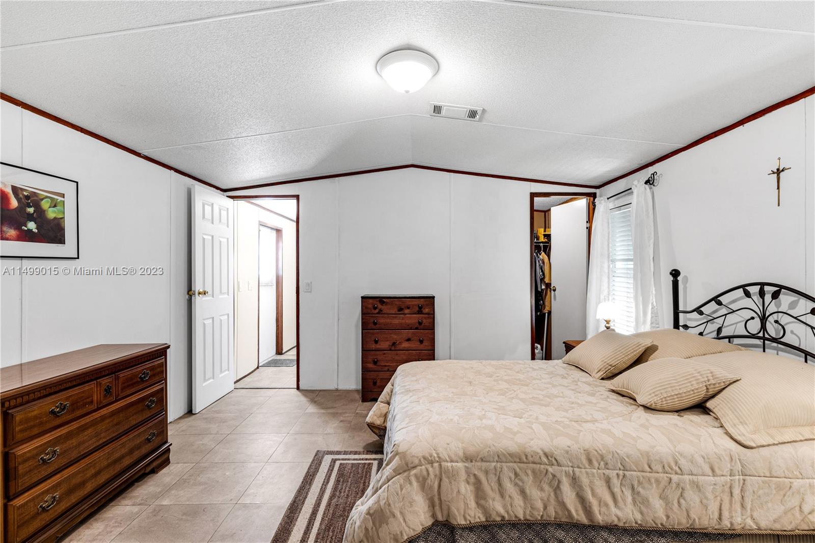 35250 Southwest 177th Court, Unit 77 Homestead, FL 33034 - Photo 18 of 30 a bedroom with a bed and a dresser with mirror