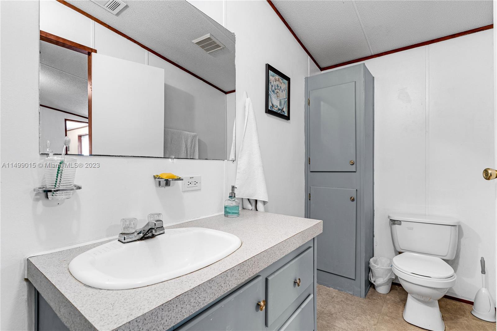 35250 Southwest 177th Court, Unit 77 Homestead, FL 33034 - Photo 20 of 30 a bathroom with a sink toilet and mirror