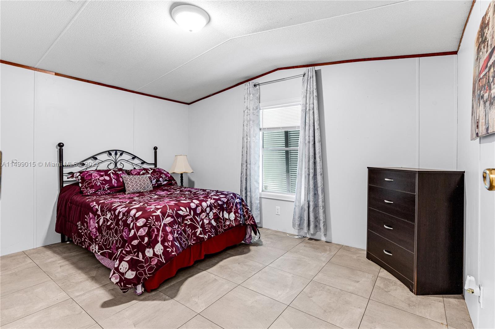 35250 Southwest 177th Court, Unit 77 Homestead, FL 33034 - Photo 23 of 30 a bedroom with a bed and a mirror
