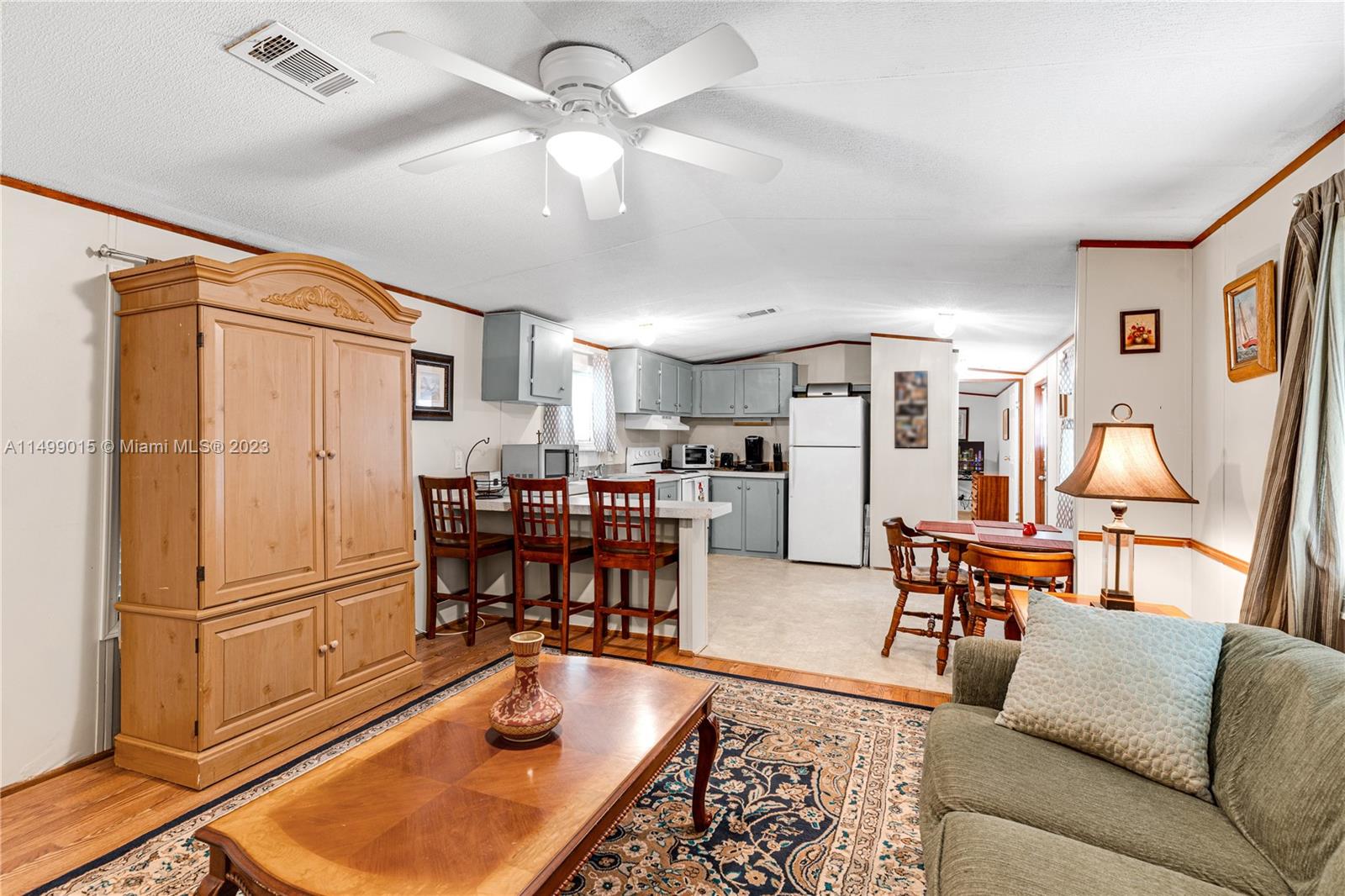 35250 Southwest 177th Court, Unit 77 Homestead, FL 33034 - Photo 8 of 30 a living room with furniture a refrigerator and kitchen view