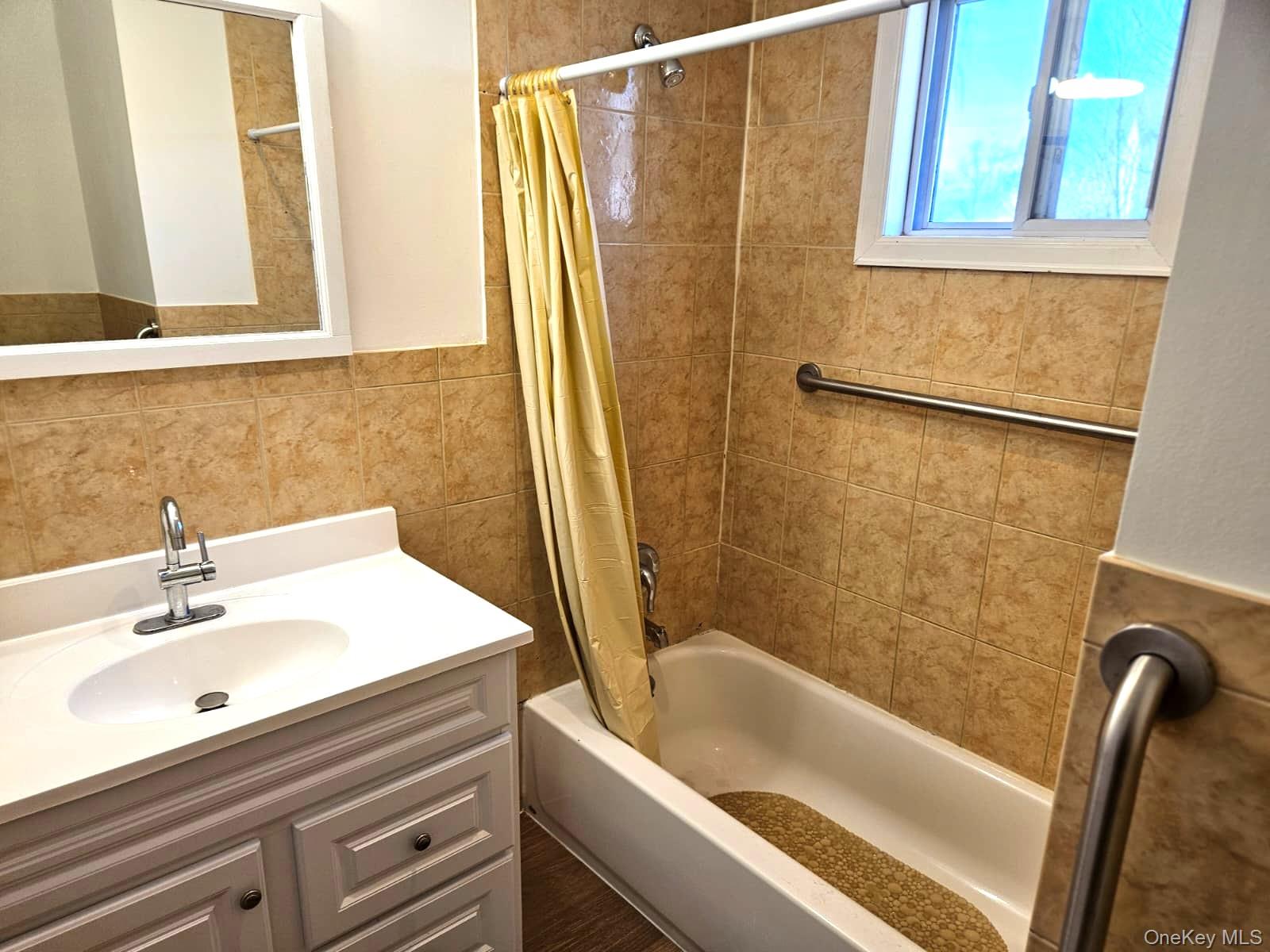56 Applegate Drive Central Islip, NY 11722 - Photo 14 of 33 a bathroom with a sink a bathtub and a shower