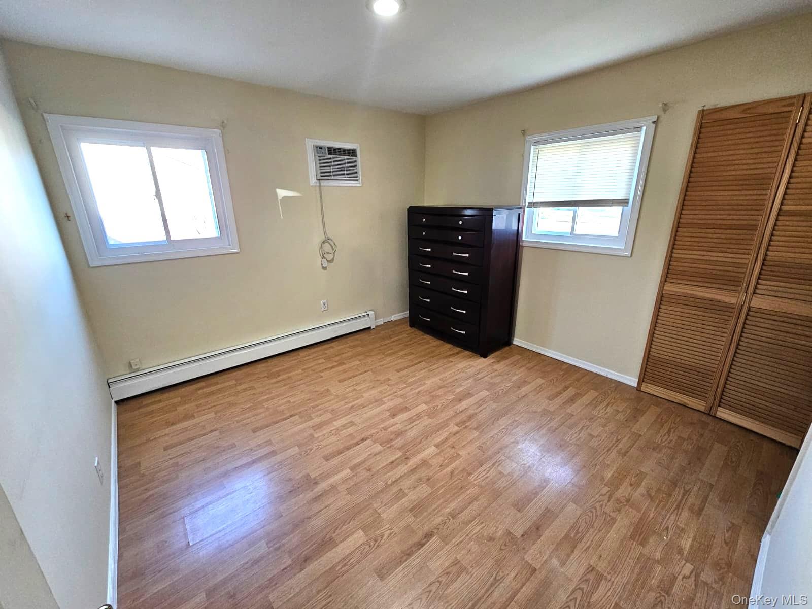 56 Applegate Drive Central Islip, NY 11722 - Photo 5 of 33 an empty room with wooden floor and windows